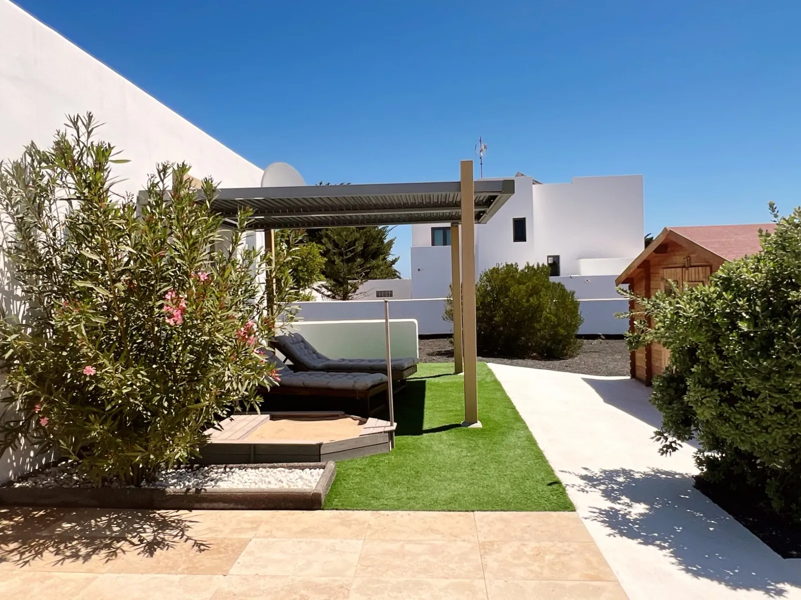 Jardín con pérgola y casita infantil en Chalet Emily