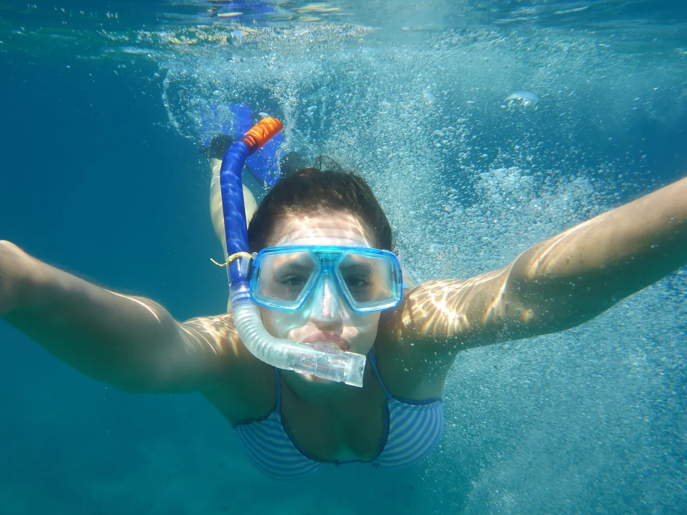 Frau mit Maske und Schnorchel unter Wasser im Atlantik