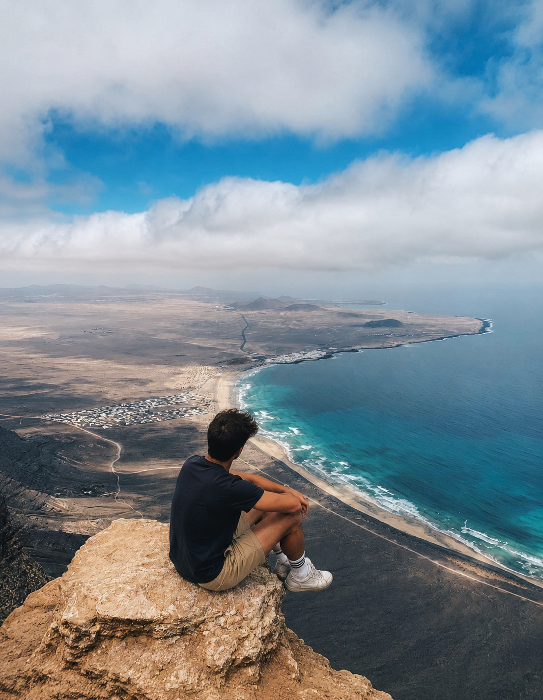 Hiker looking over Famara beach from the top of the cliffs