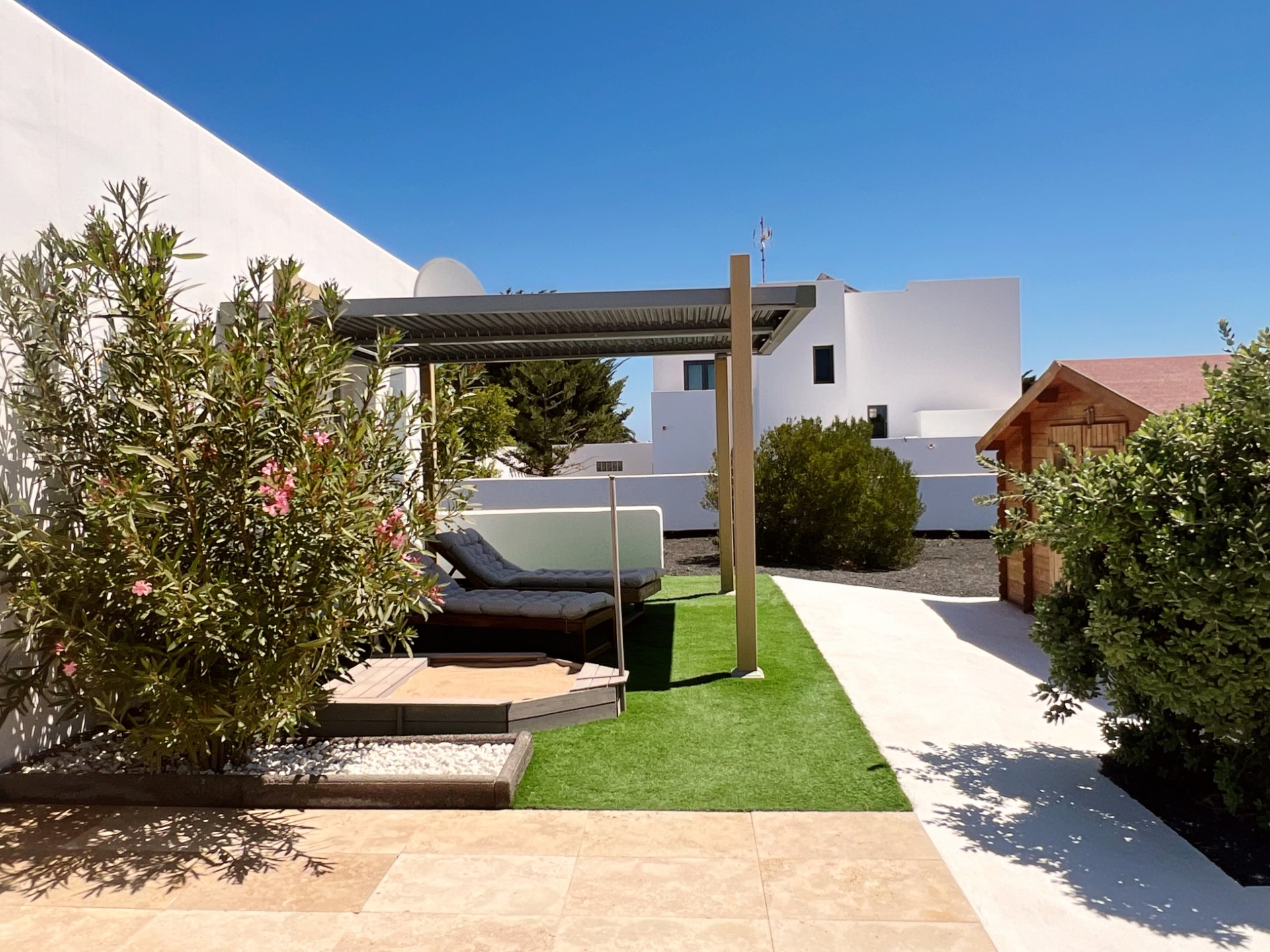Jardín con pérgola y casita infantil en Chalet Emily