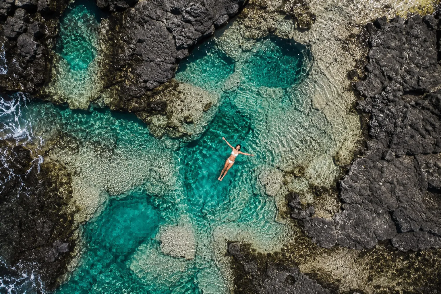 Mujer flotando en las piscinas naturales de Los Charcones, Lanzarote