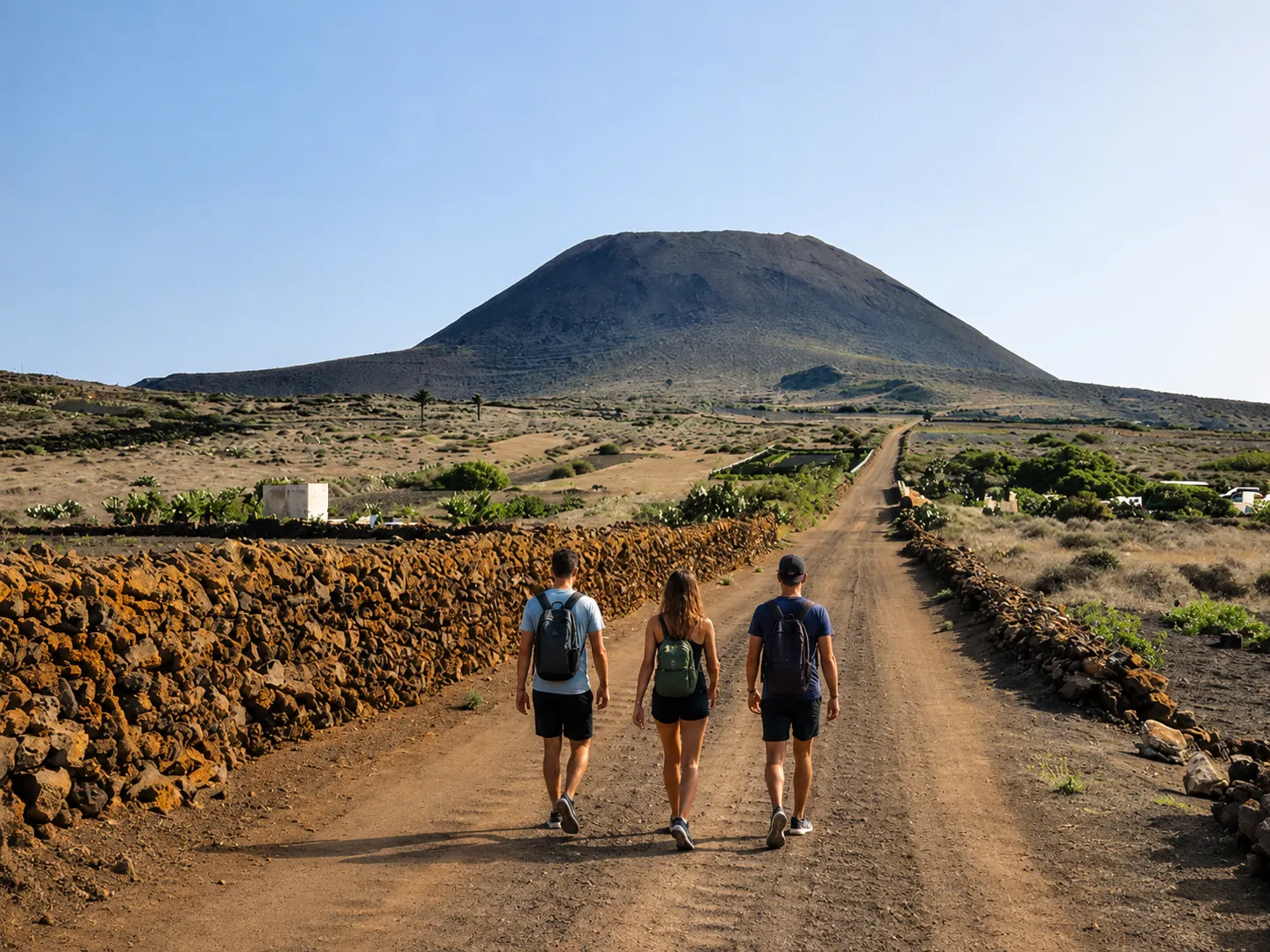 Grupo de senderistas caminando hacia un volcán en Lanzarote