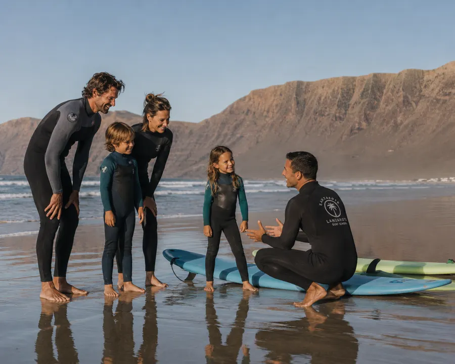 Familie mit zwei Kindern beim Surfkurs am Strand von Famara auf Lanzarote