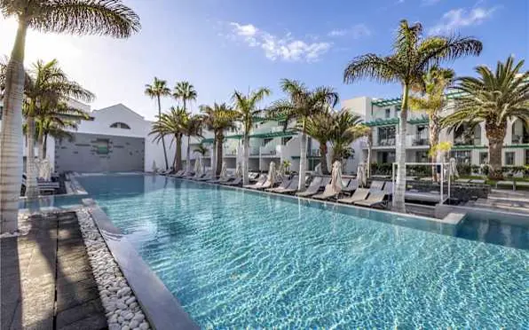 Pool of the Barceló Teguise Beach surrounded by palm trees
