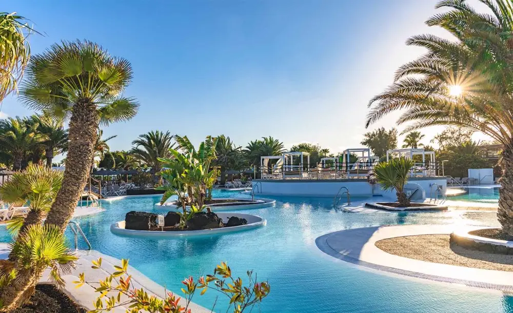 Central pool of the Elba Lanzarote Royal Village surrounded by palm trees