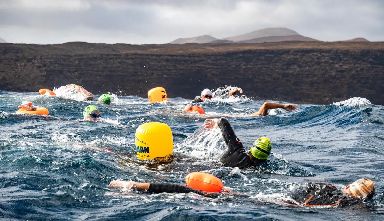 Open-water swimming crossing off the volcanic coast